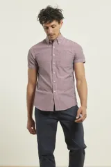 Camisa manga corta con cuello abotonado y estampado a cuadros pequeños en tonos rojo y blanco.