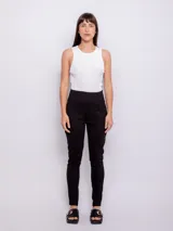 Pantalón negro de tiro alto con diseño de doble botonadura frontal, alforzas decorativas y corte ajustado en las piernas.