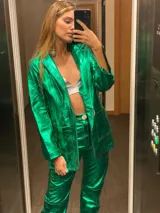 Blazer de cuero color celeste metalizado, con solapas, cierre con broches tipo tanca de madera y puños con detalle de piel sintética marrón.