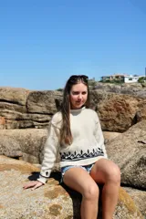 Sweater tejido a mano en lana merino color crema con diseño geométrico en negro en el pecho y puños.