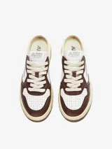 Zapatillas Autry Medalist Mule, de cuero blanco con puntera perforada y detalles en cuero marrón. Tiene suela de goma color crema y logo de la marca en el lateral.