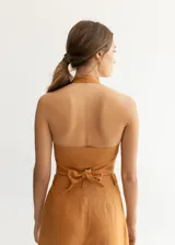 Top color ocre de lino con escote halter y espalda descubierta. Se ata en la espalda con lazos.