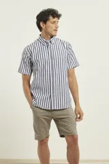 Camisa de manga corta con estampado de rayas verticales en azul y blanco, cuello abotonado y bolsillo frontal en el pecho.