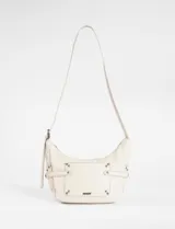 Bandolera de cuero vegano color beige, con diseño de bolsillo frontal decorado con tachas metálicas y correas laterales ajustables. Cuenta con correa larga regulable para llevar al hombro o cruzada.