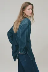 Jean ancho de tiro alto confeccionado en denim de algodón con ligero stretch, de color azul oscuro con efecto deslavado y pliegues frontales.