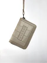 Mini billetera de cuero con textura efecto cocodrilo y cierre perimetral. Presenta un parche central con el logo de la marca grabado.