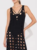 Vestido negro midi con aberturas geométricas y tiras finas.