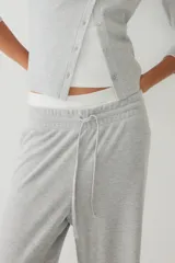 Pantalón de punto waffle con cintura elástica, cordón ajustable y piernas amplias de corte recto.