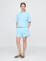 Short de algodón color celeste, con cintura elástica, bolsillos laterales y logo de la marca bordado en la parte inferior.