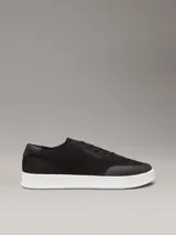 Zapatillas de perfil bajo Calvin Klein, confeccionadas en tejido de punto transpirable color negro. Presentan puntera revestida, trabilla trasera de piel y suela de goma blanca con logo grabado en la mediasuela.