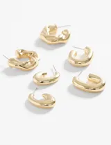 Set de tres pares de aros metálicos dorados con diseño curvo y grueso. Un par con superficie texturizada, otro con forma de gota y otro con forma de U.