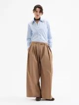 Camisa de algodón con lycra en color celeste claro, de corte clásico y manga larga. Presenta apliques de piedras de cristal en las puntas del cuello y una cartera oculta con botones.