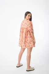 Vestido corto verde con estampado floral, cuello alto, mangas cortas abullonadas y corte holgado.