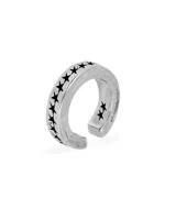 Earcuff de plata con diseño abierto y grabado de estrellas negras en todo el contorno.
