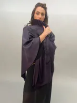 Ruana de lana merino tejida, teñida y estampada, con cuello plisado en fieltro de lana merino.