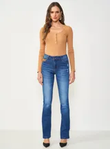 Jean de mezclilla azul oscuro con efecto lavado y sutil desgaste, de corte recto o ligeramente acampanado (bootcut).