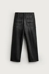 Pantalón jeans relaxed fit de mezclilla azul oscuro, con estilo carpintero que incluye bolsillos laterales y presillas de herramientas. Cuenta con costuras pespuntadas en contraste y cierre frontal con botón y cremallera.