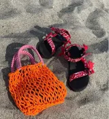 Sandalias negras con tiras rojas estampadas con diseño de bandana.