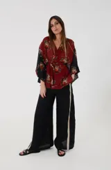 Kimono de gasa con motivos florales, que combina tonos bordó y negro en el cuerpo y las mangas. Presenta mangas anchas cuadradas y faja ancha tipo lazo para atar en la cintura.