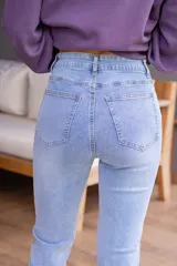 Jean celeste de tiro alto con cinco bolsillos, cierre frontal con cremallera y botón.