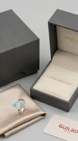 Anillo abierto de plata 925 con diseño geométrico triangular y detalles en piedra turquesa con vetas oscuras.