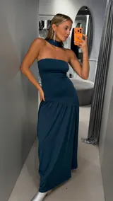 Vestido largo color verde oscuro, de corte strapless con escote recto y falda larga con caída fluida. Incluye una gargantilla a juego.