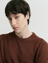 Sweater de punto con escote redondo, confeccionado en algodón con textura de punto fantasía en cuerpo y mangas, y terminaciones en punto canalé en cuello y puños.