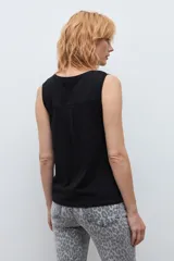 Musculosa blanca básica de corte recto, con escote redondo a la base y tirantes anchos.