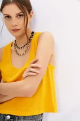 Musculosa de algodón color amarillo vibrante, con escote redondo pronunciado y corte al cuerpo.