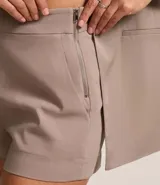 Short lila de tejido bengaline, con bolsillos delanteros y cremallera lateral.