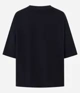 Remera oversize blanca de manga corta, con cuello redondo y diseño holgado, confeccionada en mezcla de algodón y poliéster.