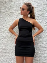 Vestido corto negro de crepe, con un solo hombro y corte ajustado al cuerpo.
