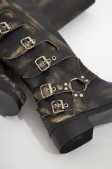 Botas de cuero negro de caña alta con hebillas plateadas y suela de goma.