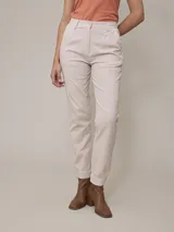 Pantalón color beige de corte recto, con pinzas en la cintura, bolsillos laterales y tobillos ajustados.