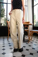 Pantalón cargo de cuerina color beige, tiro alto, corte holgado y bolsillos laterales.