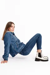 Botinetas de cuero vacuno color blanco tiza, con elásticos laterales negros, suela de goma antideslizante y plataforma con taco cuadrado.