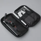 Riñonera negra con correa ajustable para usar como bandolera. Fabricada con material xPac X21 impermeable, cuenta con apertura de 180°, 7 bolsillos internos, 2 bolsillos externos, detalles en color ladrillo y cierres impermeables.