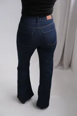 Pantalón de jean corte oxford, color azul oscuro, con tiro alto y cierre frontal con botón metálico.