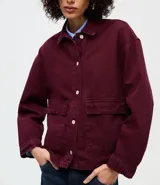 Camisa overshirt de sarga color bordó, con cuello polo, mangas largas, cierre frontal con botones y dos bolsillos delanteros aplicados. Presenta un corte amplio y estructurado.