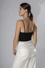 Crop top negro con breteles finos y escote con tiras cruzadas.