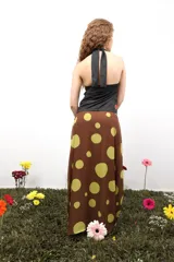 Falda larga de gasa con estampado tipográfico en tonos bordó sobre fondo beige. Presenta un diseño de doble tela con caída fluida y cierre lateral oculto.