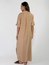 Vestido largo de lino color azul, con diseño estilo camisero, cuello camisero, cierre frontal con botones de madera y mangas largas con presilla para arremangar.