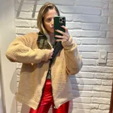 Campera gamulan marrón con detalles en marrón claro, cierre frontal y cuello con solapas.