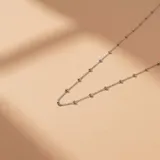 Cadena de plata 925 con diseño de eslabones finos intercalados con pequeñas esferas metálicas.