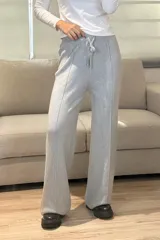 Palazzo de punto en color beige, con cintura elástica y cordón ajustable. Presenta un diseño de pierna ancha con costuras verticales decorativas en el frente.
