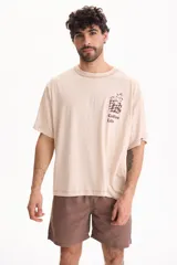 Remera de algodón de manga corta, fit oversize, color beige con estampa en el pecho con diseño de café y texto "Coffee Life".