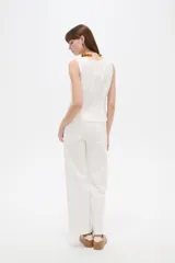 Musculosa blanca sin mangas de viscosa, con ajuste al cuerpo, cuello a la base y detalles de vivos.