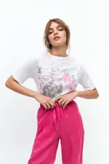 Remera blanca de algodón con estampado de flor en tonos grises y rosados.