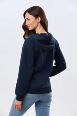 Campera deportiva azul marino con capucha y cierre frontal, confeccionada en algodón con felpa. Presenta cordones ajustables al tono y puños ribeteados.