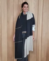 Bufandón de lana lambswool color gris oscuro, suave y liviano, de diseño amplio y versátil que permite usarlo como ruana.